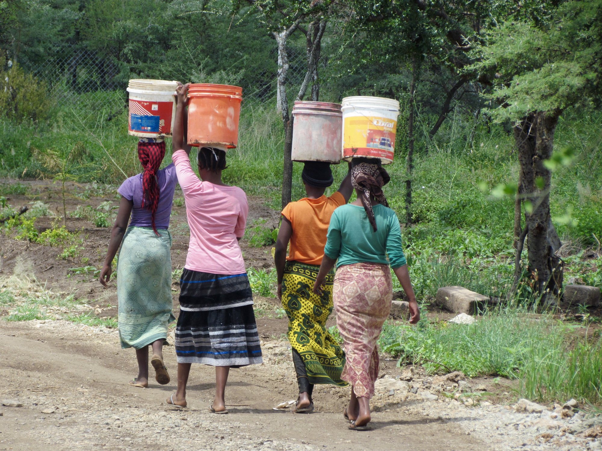 Women carrying water containers in a member village